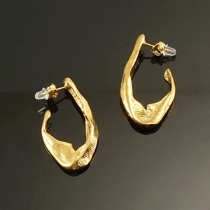 Detailed view of irregular 18K gold plated titanium steel earrings with textured finish