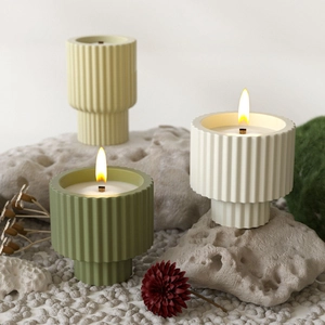 Minimalist striped candle jars with wooden wicks on natural stone and moss display