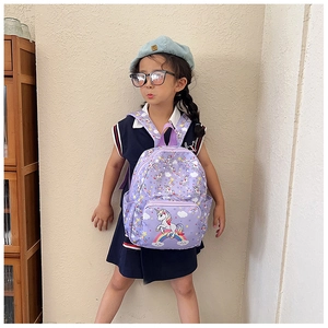 Detail view of purple toddler backpack with cute unicorn and rainbow print on young girl
