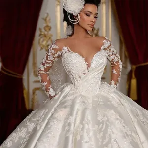 Close-up of luxury bridal lace detailing with sequins on long sleeve white ball gown