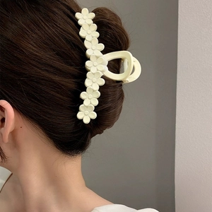 Detailed back view of a large pale yellow flower hair claw clip holding hair elegantly
