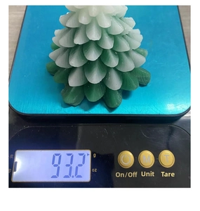 Detailed view of 93.2g green Christmas tree candle on a digital scale for weight check