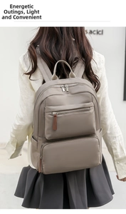 Detail showing high-density nylon fabric and multi-layered zippers on the grey backpack