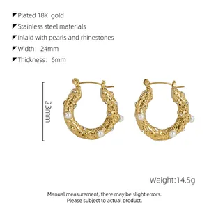 Détail macro de boucles d'oreilles en acier doré 18k avec texture lave et perles