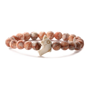 Detail of red-brown and cream beads on elastic bracelet with white dolphin pendant