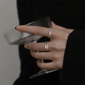 Detail of silver-colored knotted rings with micro-inlaid cubic zirconia on hand