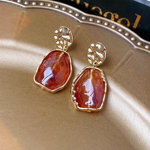 Vue détaillée de boucles d'oreilles vintage en résine ambrée et finition dorée martelée