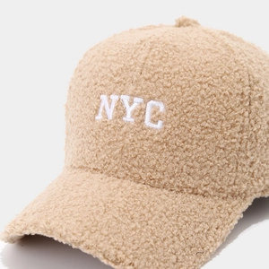Close-up of NYC embroidered beige sherpa baseball cap with fuzzy sherpa fleece texture