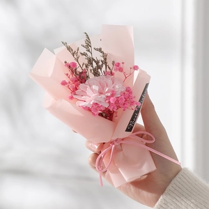 Detail of a handmade pink carnation and gypsophila bouquet with a Best Wishes tag