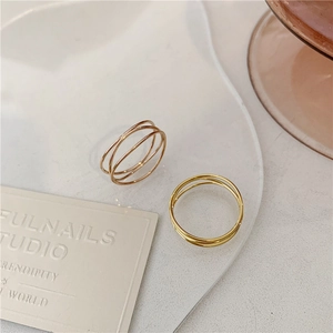Close-up of minimalist triple-layered 18K gold plated ring on a white decorative tray