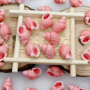 Detail of pink seashell ceramic beads on a bamboo tray for DIY jewelry making