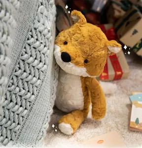 Close-up of soft plush fox toy resting on a knit blanket in a cozy gift setting