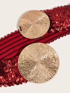 Macro view of a red sequin waist belt with dual textured golden circular metal buckles