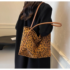 Close-up of leopard print canvas tote bag styled on model with a minimalist aesthetic
