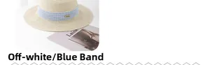 Detail of a beige straw hat with blue textured ribbon and gold metal accent on side
