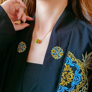 Modella che indossa collana placcata oro 18K con ciondolo a perla smaltata verde rétro