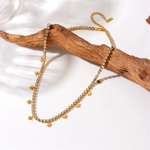 Gold-plated chain necklace with sparkling star charms displayed on natural wood