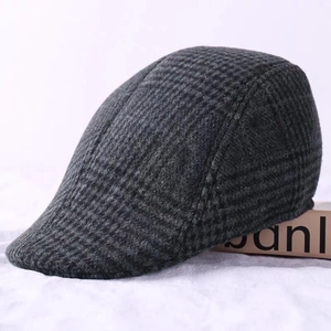 Side view detail of dark grey plaid pattern and thick wool fabric on the flat cap