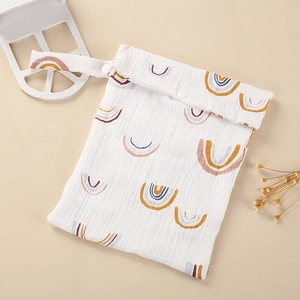 Detail of soft cotton muslin diaper bag with rainbow print and snap button handle