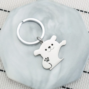 Cute cartoon puppy stainless steel keychain with paw print on white marble coaster