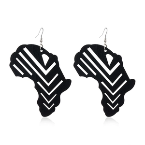 Macro shot of black wooden African map earrings with white geometric arrow patterns