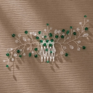 Detailed view of handmade silver branch hair comb with green crystals and leaf design