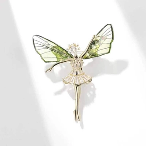 Macro shot of dancing girl brooch with green wings and cubic zirconia inlay