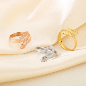 Three adjustable snake rings in gold, silver, and rose gold on silk fabric background