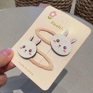 Détail de barrettes lapin blanc pailleté sur ruban rose pour coiffure d'enfant