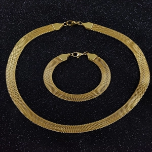 Close-up of golden flat mesh woven necklace and bracelet set with lobster clasps