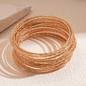 Set di 20 bracciali rigidi dorati testurizzati con finitura opaca e design multistrato