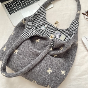 Detail view of the gray tote bag interior showing the bow embroidery and magnetic closure