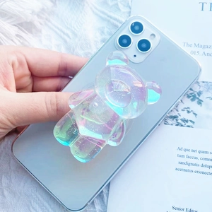 Cute colorful transparent bear shaped collapsible cell phone grip on a blue smartphone