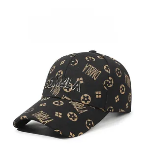 Detail of black baseball cap featuring gold DM&LA embroidery and monogram pattern