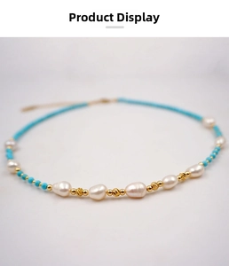 Detail of baroque pearls, golden beads, and turquoise accents on a handmade necklace