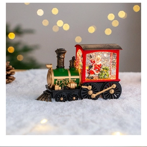 Christmas train snow globe music box with Santa Claus, glowing holiday home table decor.