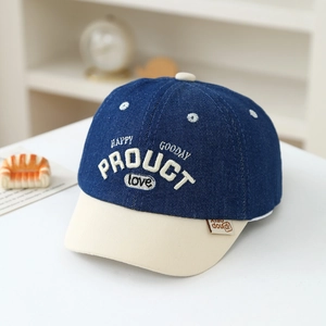Dettaglio del berretto da baseball in denim blu per neonati con ricamo bianco