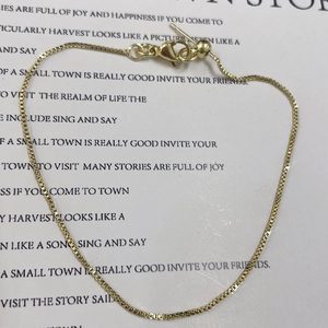 Detail of golden box chain bracelet with lobster clasp and adjustable sliding bead