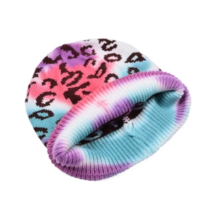 Macro shot of knit beanie featuring colorful tie-dye patterns and black leopard spots