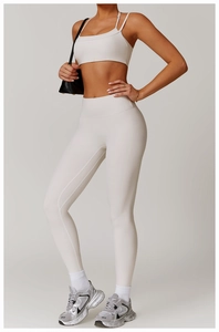 Close-up of high-waisted compression leggings and sports bra in ivory white fabric