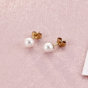 Detailed view of elegant round white pearl earrings with 18k gold plated titanium studs