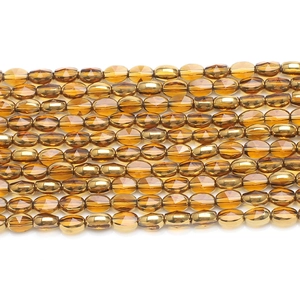 Close-up of faceted golden glass rice beads for DIY jewelry and beaded accessories