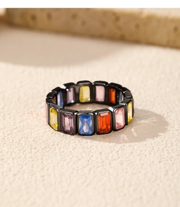 Macro shot of colorful rainbow baguette gems on a black band minimalist ring