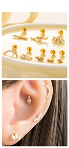 Detailed view of gold titanium earrings set with white zircon stones on model ear