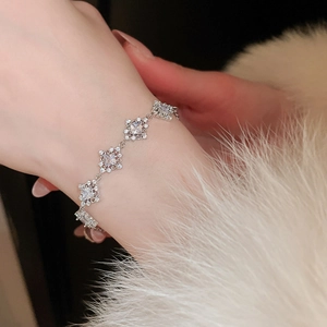 Detail of silver bracelet with geometric blue zircon links on a soft fur background