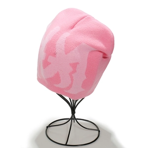 Close-up of pink knit beanie with jacquard pattern on a black metal display stand