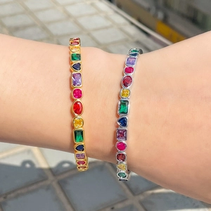 Detail shot of gold and silver open bracelets with colorful square and heart zircon stones