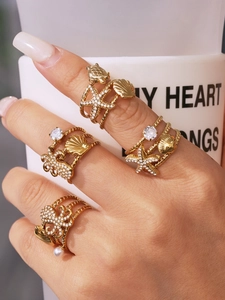 Detailed close-up of ocean-themed gold rings featuring starfish, turtle, and shell designs