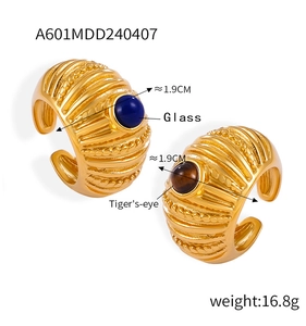 Detail of vintage textured gold rings featuring blue glass and tiger's-eye stone stones