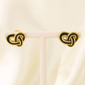 Detail of vintage heart-shaped knot earrings in gold and black enamel finish